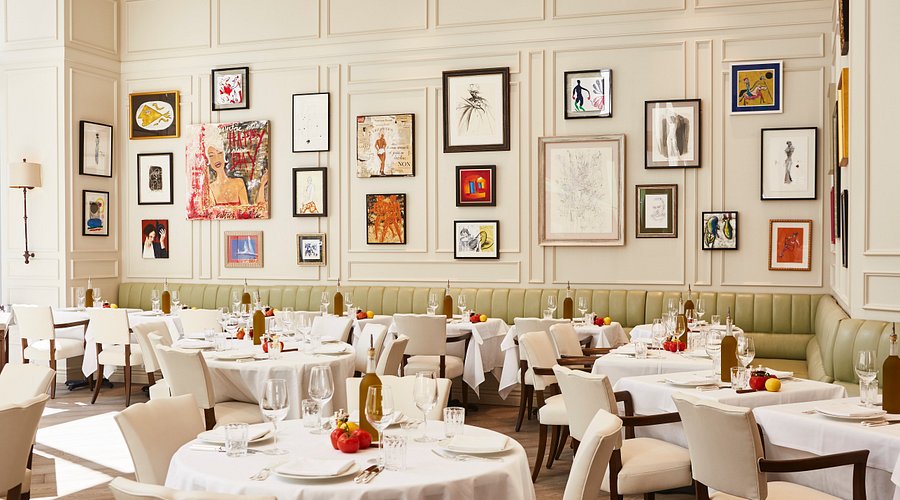 Ristorante luminoso ed elegante, con tovaglie bianche, tavoli ben apparecchiati, banquette verde chiaro e pareti ornate da un eclettico mix di opere d'arte incorniciate di vari stili e dimensioni.