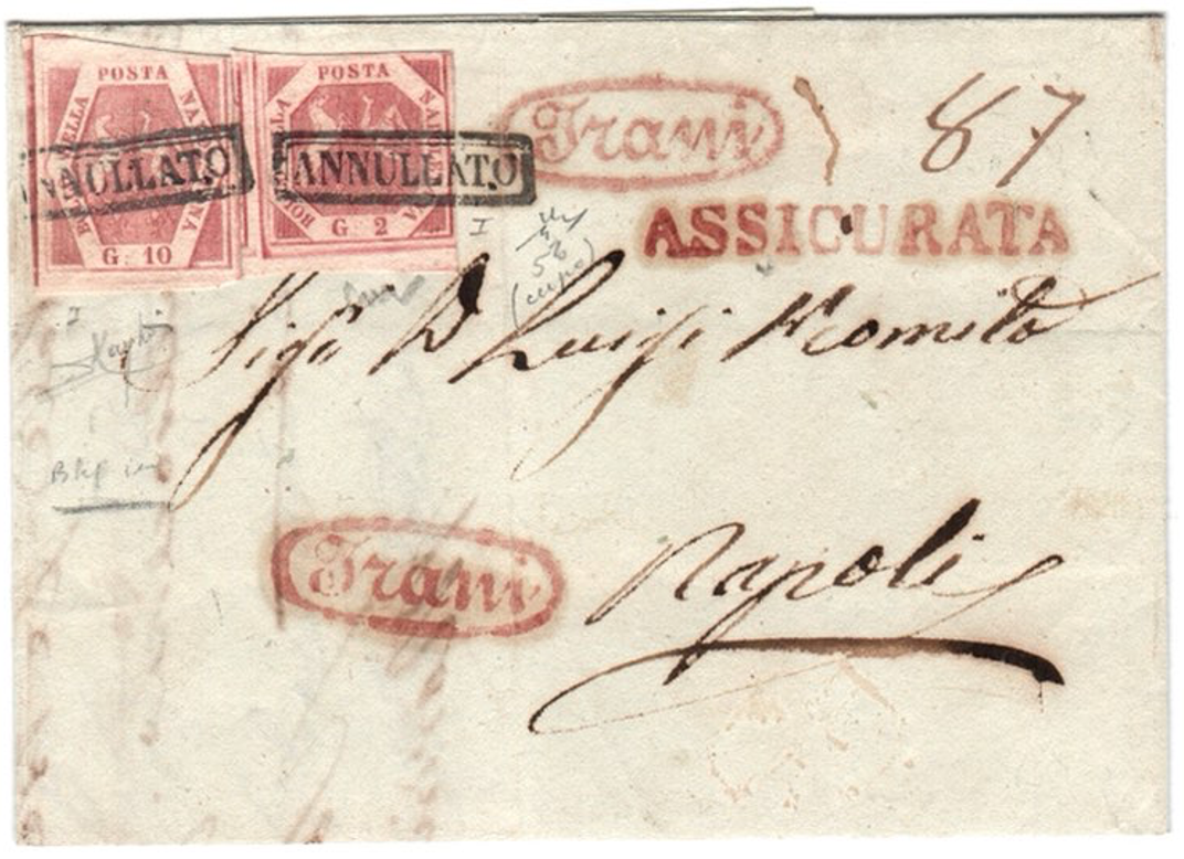 Una busta d'epoca con francobolli rossi e testo scritto a mano. La busta è indirizzata a "Signor D. Luigi Momito" di Napoli. Sono visibili diversi timbri, tra cui "ANNULATO" e "ASSICURATA", in inchiostro rosso.