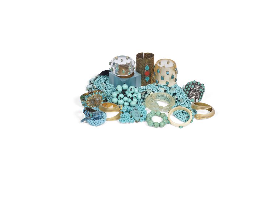 Una collezione di gioielli che comprende bracciali, collane e anelli color turchese, alcuni con accenti dorati. Gli articoli sono disposti su uno sfondo bianco, esibendo un mix di perline e design in metallo.