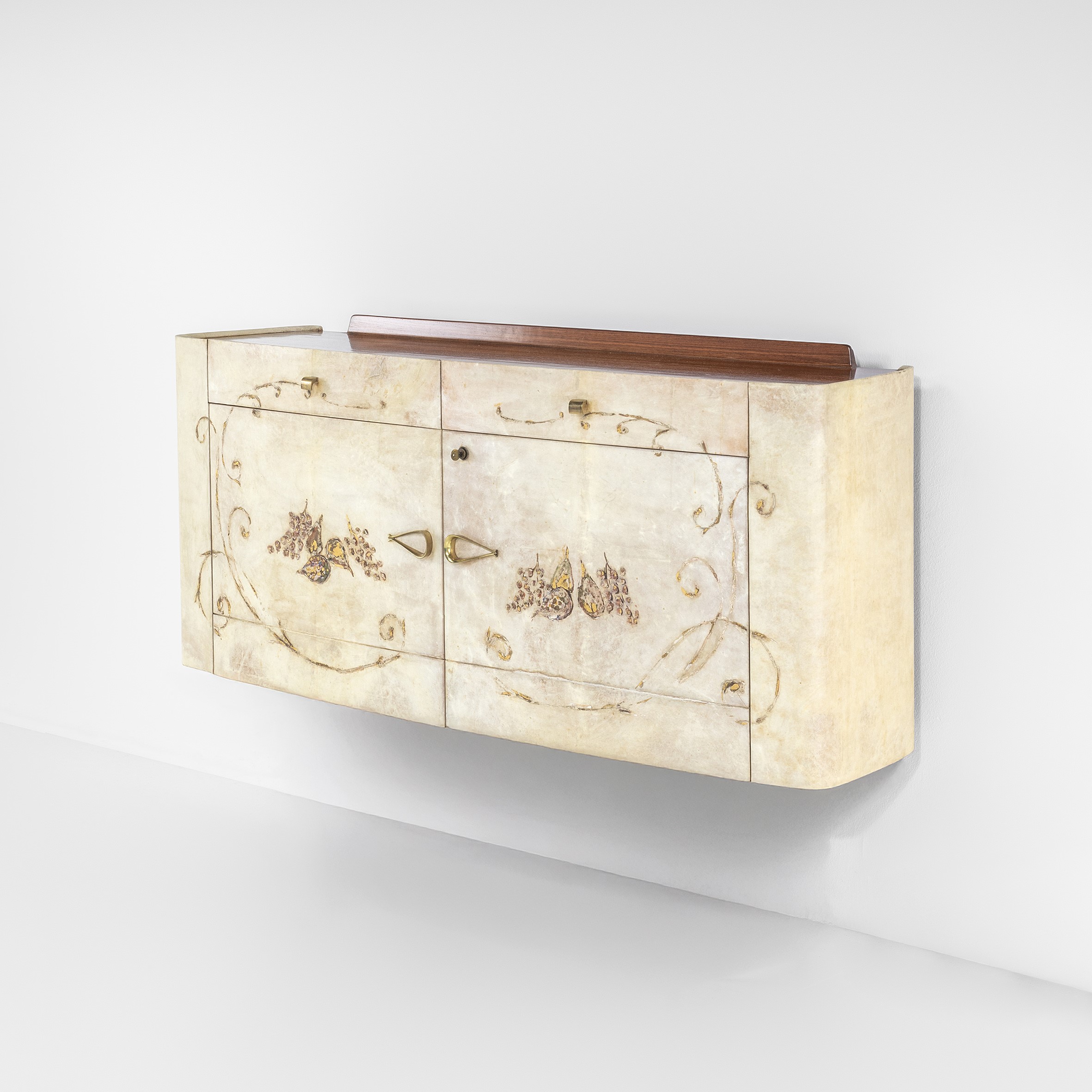 Un mobiletto decorativo da parete con decorati motivi floreali sulle ante color crema. Il pannello presenta motivi intricati e un piano superiore in legno. Il design è elegante e in stile vintage.