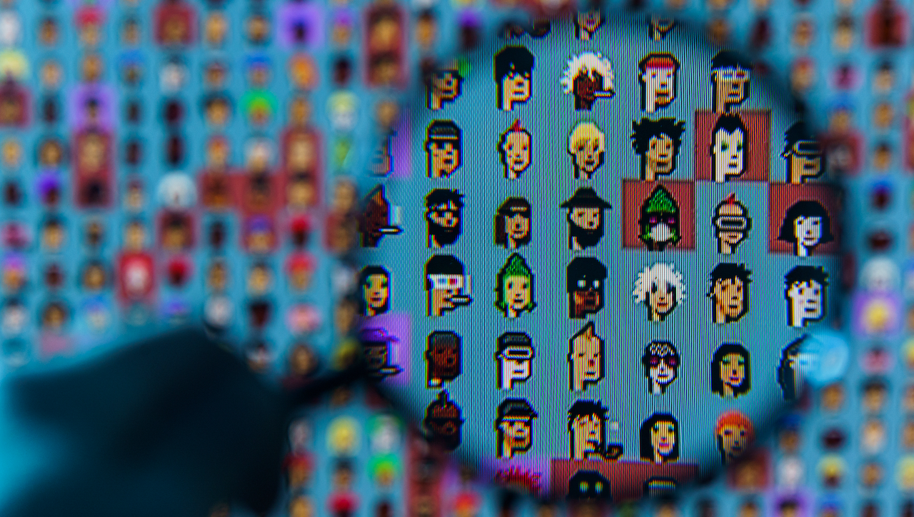 Una lente di ingrandimento si libra su uno schermo che mostra una griglia di personaggi pixel art. La sezione ingrandita evidenzia vari volti colorati e pixelati con caratteristiche diverse su uno sfondo sfocato di personaggi simili.