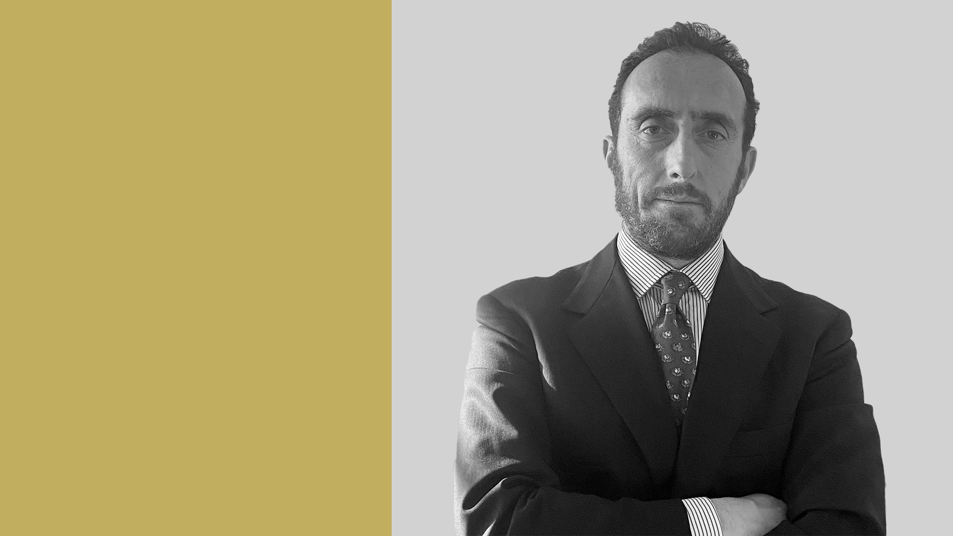 Un uomo in completo con camicia a righe e cravatta fantasia è in piedi con le braccia incrociate, trasudando autorità su uno sfondo diviso di giallo e grigio. Questa sorprendente immagine in bianco e nero accenna sottilmente ai temi del debito privato.