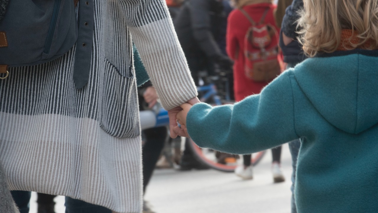 Un adulto e un bambino camminano mano nella mano. La foto è collegata al tema del trust come strumento per tutelare minori e incapaci.