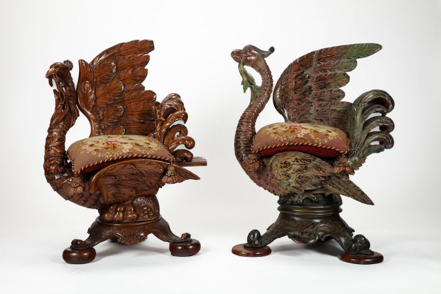 Due sedie in legno decorato, che ricordano cigni con ali sollevate, presentano dettagli in piume e sedute rivestite in arazzo. Questi pezzi di Stefano Gabbana hanno basi intagliate e dettagli intricati, con un cigno che tiene del verde nel becco.