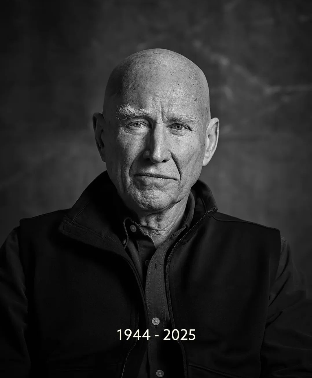 Ritratto in bianco e nero di un uomo anziano, calvo, con indosso una giacca, che guarda la fotocamera con un'espressione neutra. Il testo in basso recita "1944 - 2025".