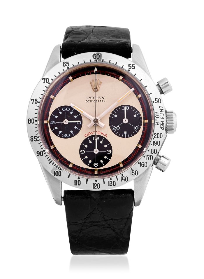 Un orologio Rolex Cosmograph Daytona d'epoca con quadrante beige, tre contatori neri, lunetta argentata con marcature nere e cinturino in pelle nera: una rarità spesso ricercata nelle migliori aste Rolex Patek Asta.