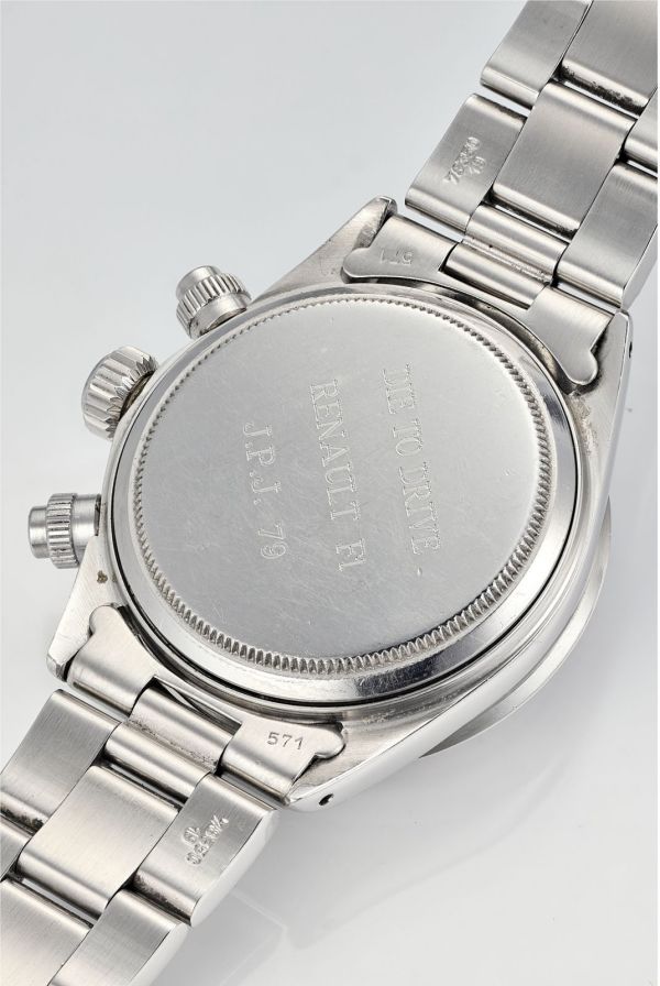 Primo piano del fondello di un orologio da polso in acciaio inossidabile con fondello inciso, bracciale in metallo e corona e pulsanti a vista. L'incisione include "THE JONVILLE", "RENALT P1" e "JRJ-79", evocando lo spirito del Rolex Campione Formula Uno.