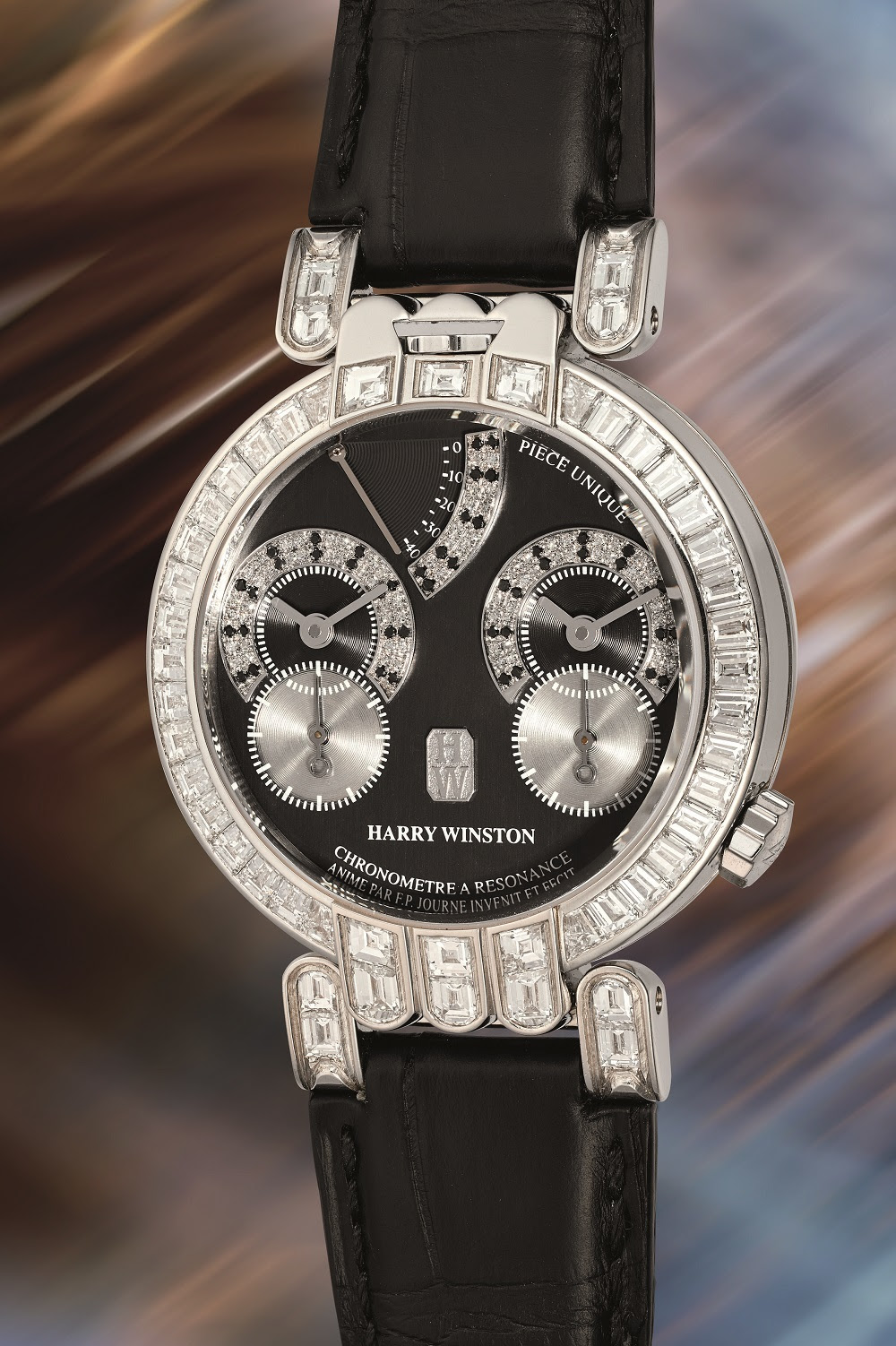 Un orologio di lusso Harry Winston con cinturino in pelle nera, dettagli di diamanti sulla lunetta e sulle anse e due quadranti secondari su un quadrante nero, che rivaleggia con Rolex e Patek, su uno sfondo sfocato e multicolore.