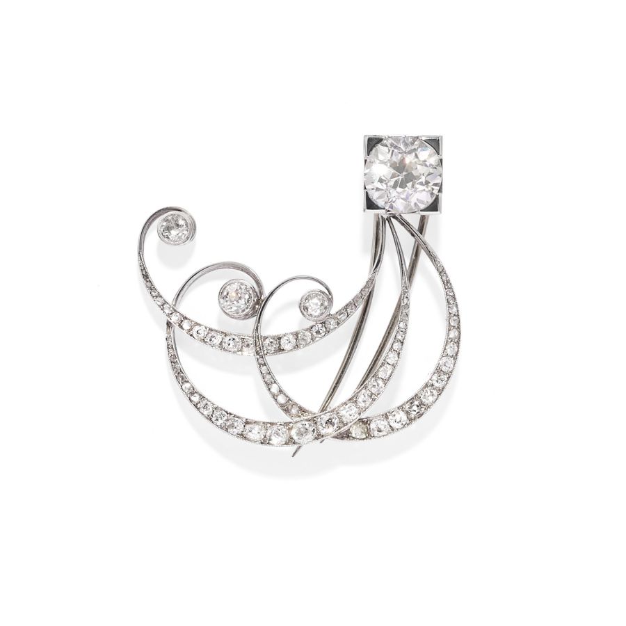 Una spilla decorativa caratterizzata da linee curve e sinuose in argento tempestate di piccoli diamanti e impreziosita da tre diamanti rotondi più grandi e perle naturali, incastonate su uno sfondo bianco semplice: un pezzo elegante per qualsiasi asta.