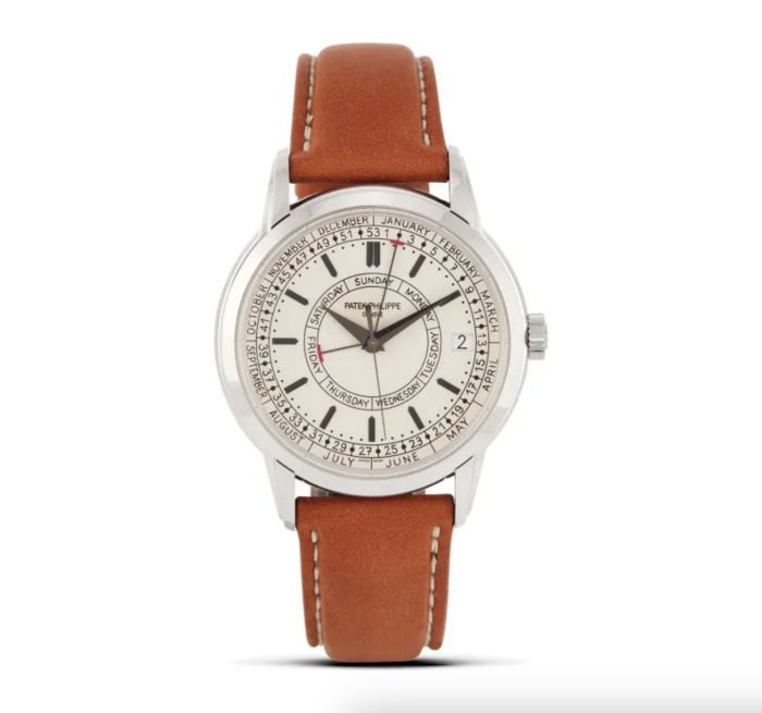 Orologio da polso in argento con quadrante bianco, indici multipli, testo nero e rosso, datario e cinturino in pelle marrone con cuciture bianche, su sfondo bianco: uno stile classico che ricorda i modelli vintage di Rolex e Patek.