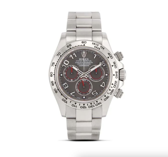 Orologio cronografo Rolex argento con quadrante nero, tre contatori, accenti rossi e bracciale a maglie in metallo. La lunetta presenta una scala tachimetrica. Questo pezzo sorprendente è presentato su uno sfondo bianco, perfetto per ogni appassionato di Rolex Patek.