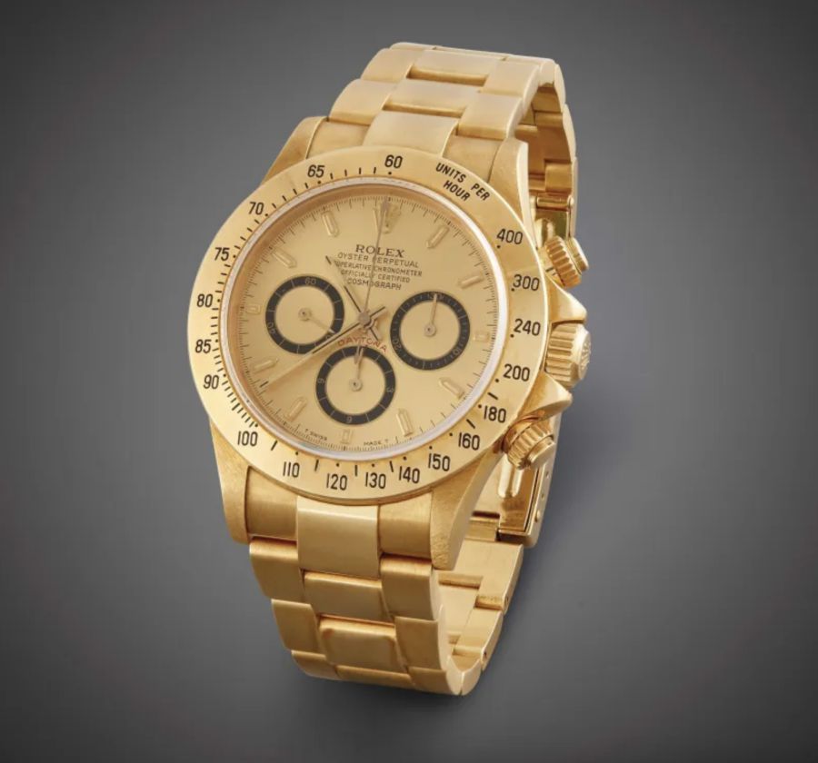 Un orologio da polso cronografo Rolex d'oro con bracciale d'oro, tre contatori e lunetta tachimetrica, su uno sfondo scuro sfumato, perfetto per qualsiasi collezione Rolex Patek Asta.
