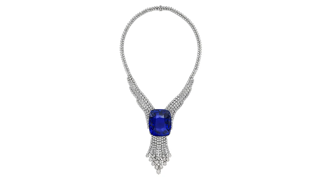 Una lussuosa collana di diamanti ispirata a Maria Antonietta, con una grande gemma blu intenso al centro e intricati dettagli di diamanti che ricordano i pezzi visti alle aste record.
