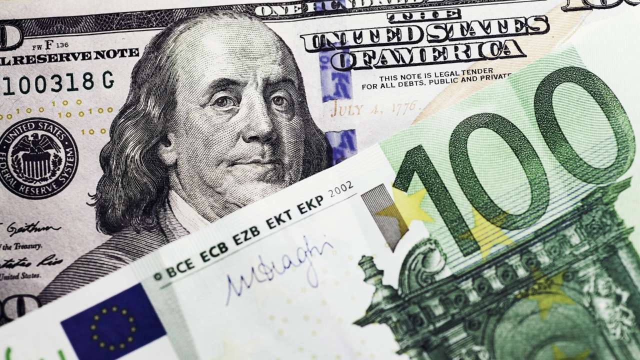 Un primo piano di una banconota statunitense da 100 dollari e di una banconota da 100 euro sovrapposte evidenzia il cambio euro-dollaro, con il ritratto di Benjamin Franklin sul dollaro e dettagli architettonici sulla banconota in euro.