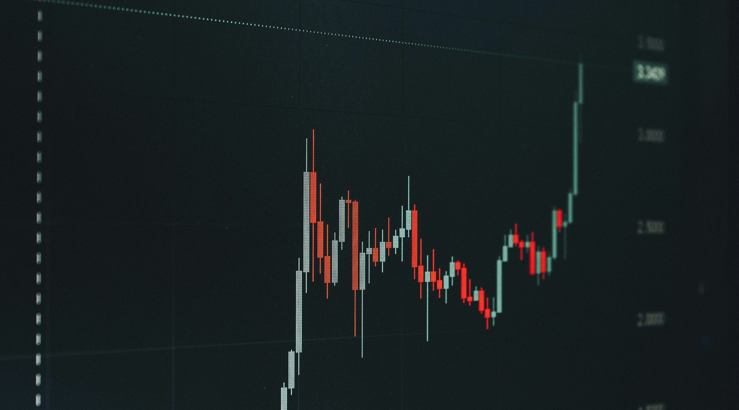 Un grafico digitale mostra i modelli a candela che mostrano la fluttuazione dei prezzi delle azioni, con un improvviso e brusco movimento verso l'alto alla fine, forse influenzato dalle tendenze di debito usa stablecoin. Lo sfondo è scuro con linee di griglia e valori numerici.