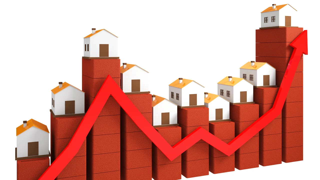 Una freccia rossa che tende verso l'alto si muove su pile di mattoni rossi con case in miniatura e negozi in cima, a rappresentare l'aumento dei prezzi e degli investimenti immobiliari.