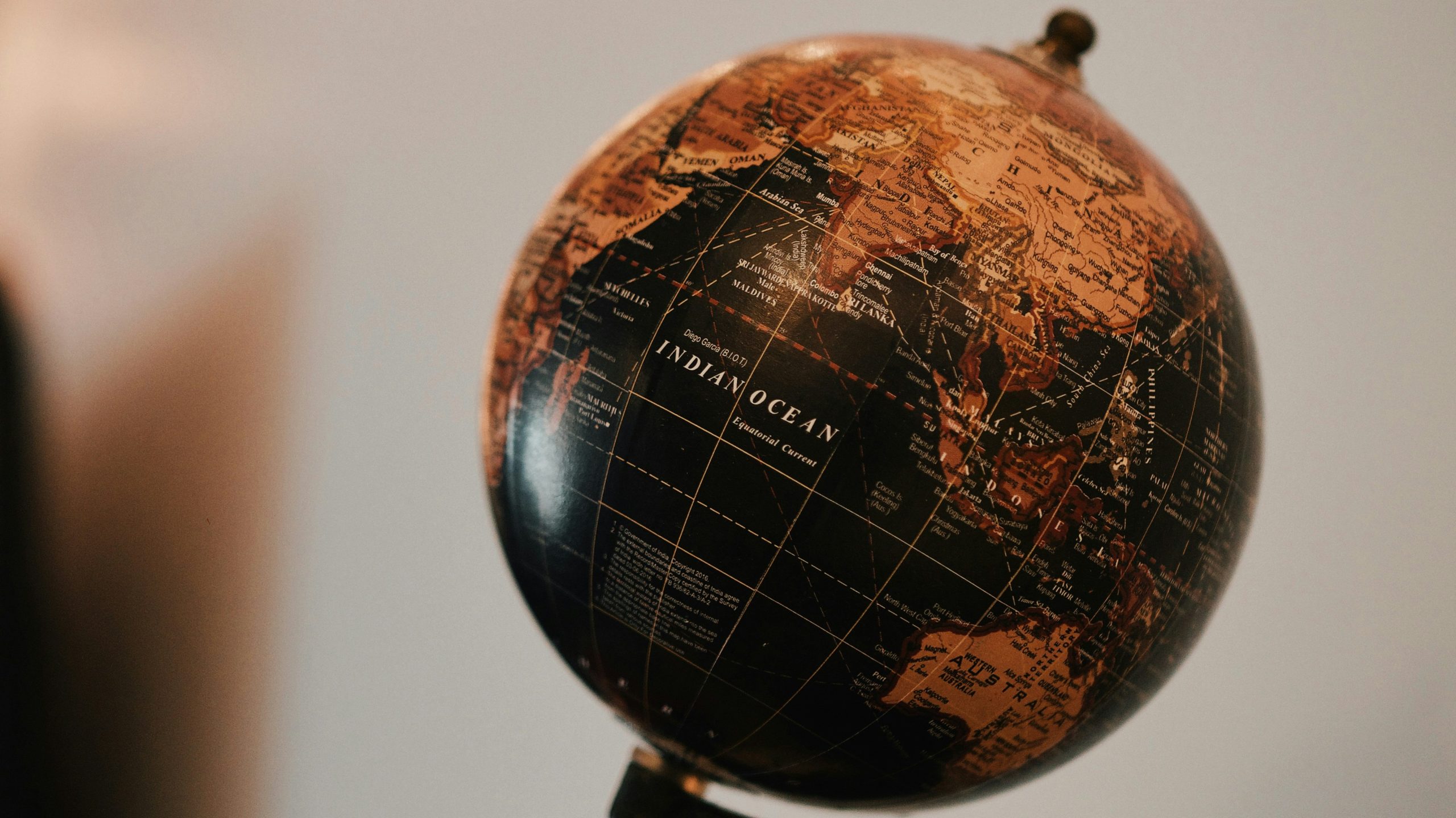 Primo piano di un mappamondo in stile vintage con l'Oceano Indiano in evidenza, che evidenzia parti dell'Africa, dell'Asia e dell'Australia - regioni centrali per i mercati emergenti Carmignac - su uno sfondo sfocato.