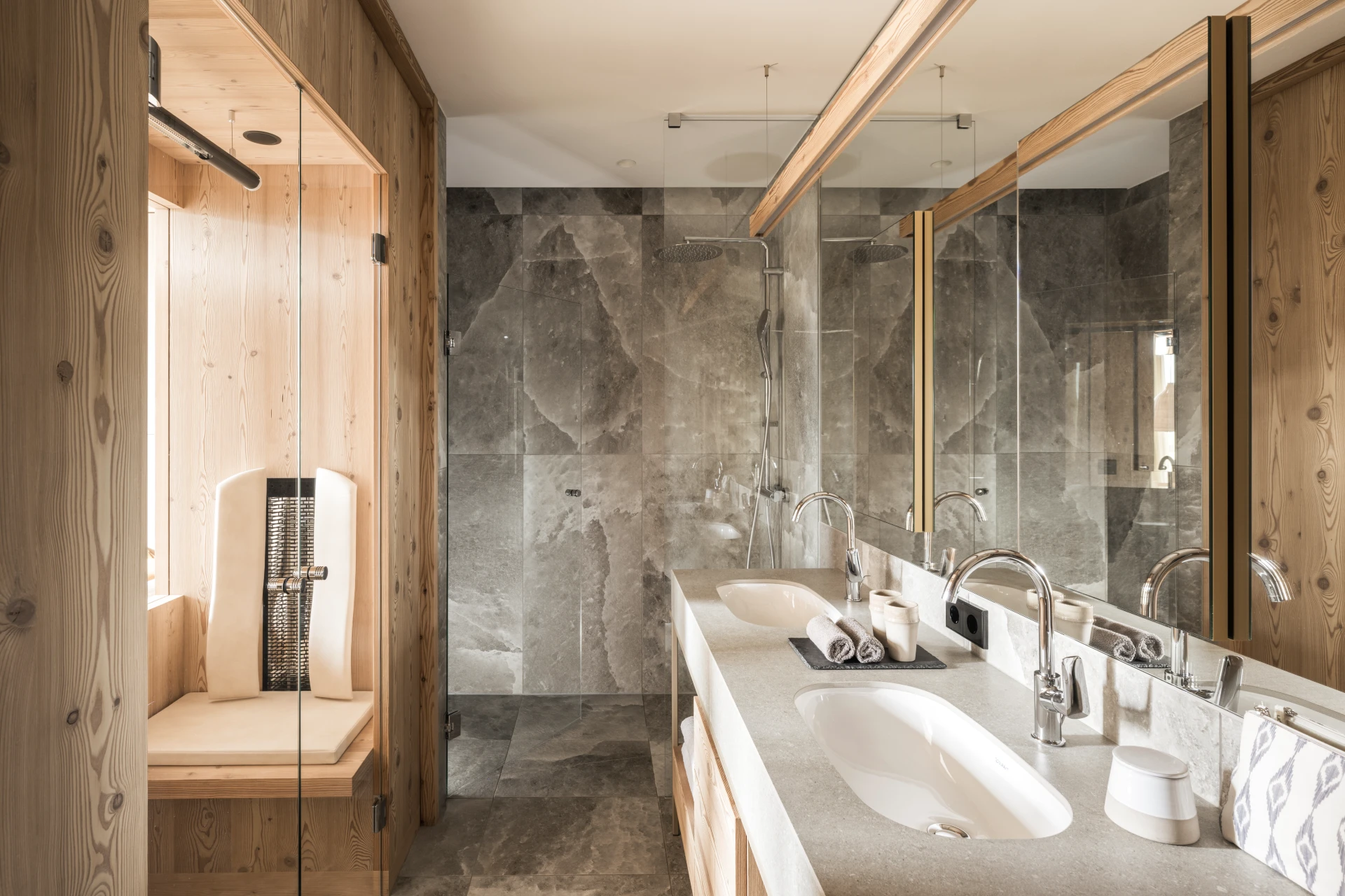 Bagno con ripiani in marmo e doccia del Falkensteiner Hotel Kronplatz.