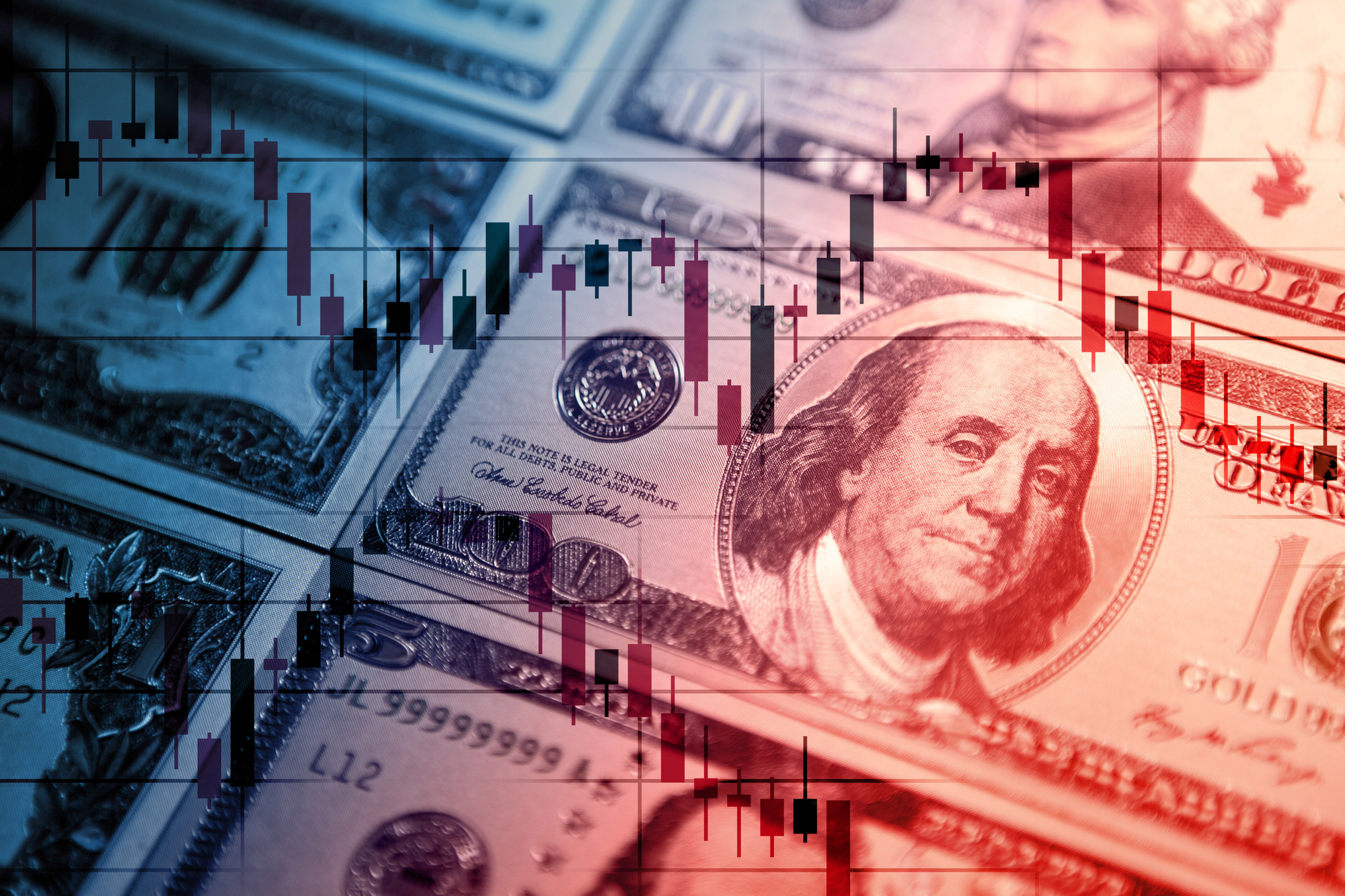 Banconote in dollari USA stratificate con una sovrapposizione trasparente di un grafico azionario a candele, simbolo dei mercati finanziari, del trading o delle tendenze economiche.