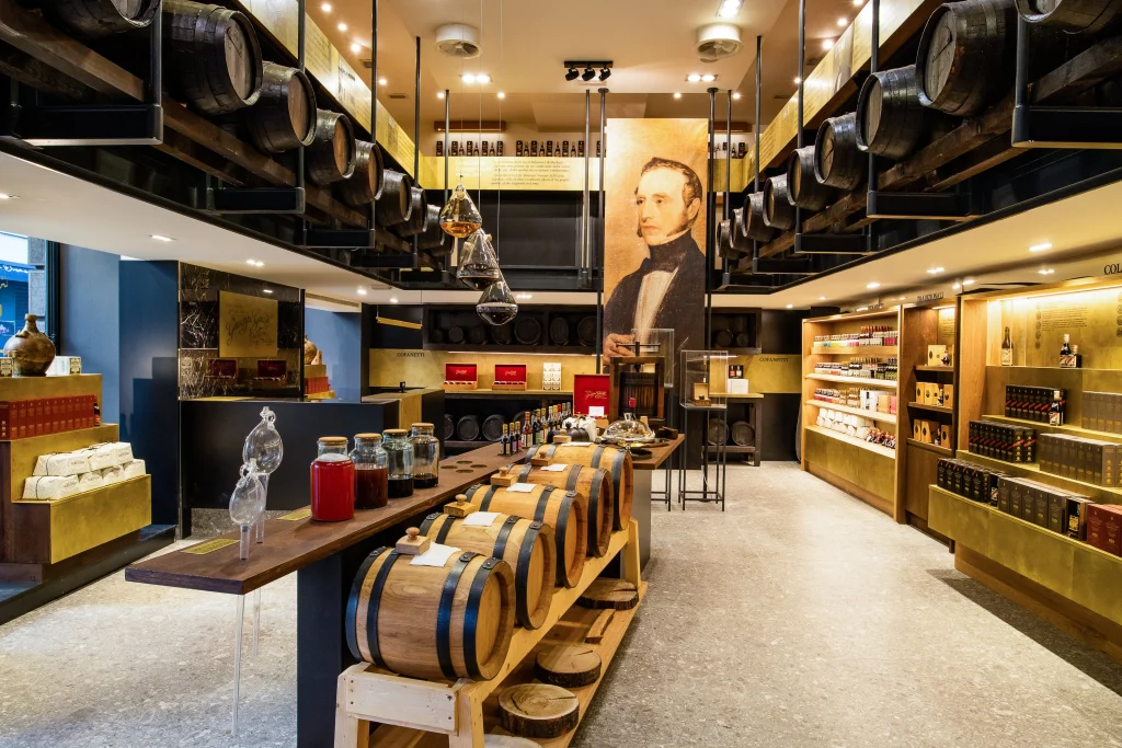 L'interno del negozio è elegante, con botti di legno, vasi di vetro e bottiglie dell'Acetaia Giusti in esposizione. Alle pareti sono allineati scaffali e sopra è appeso un grande ritratto di un uomo in abiti storici. L'atmosfera è calda ed elegante.