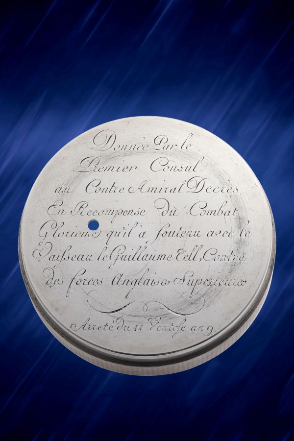 Medaglia rotonda d'argento con iscrizione in corsivo francese, su sfondo blu con striature chiare diagonali. Il testo inciso riconosce un risultato navale e fa riferimento allo storico lascito di Berthoud Asta.