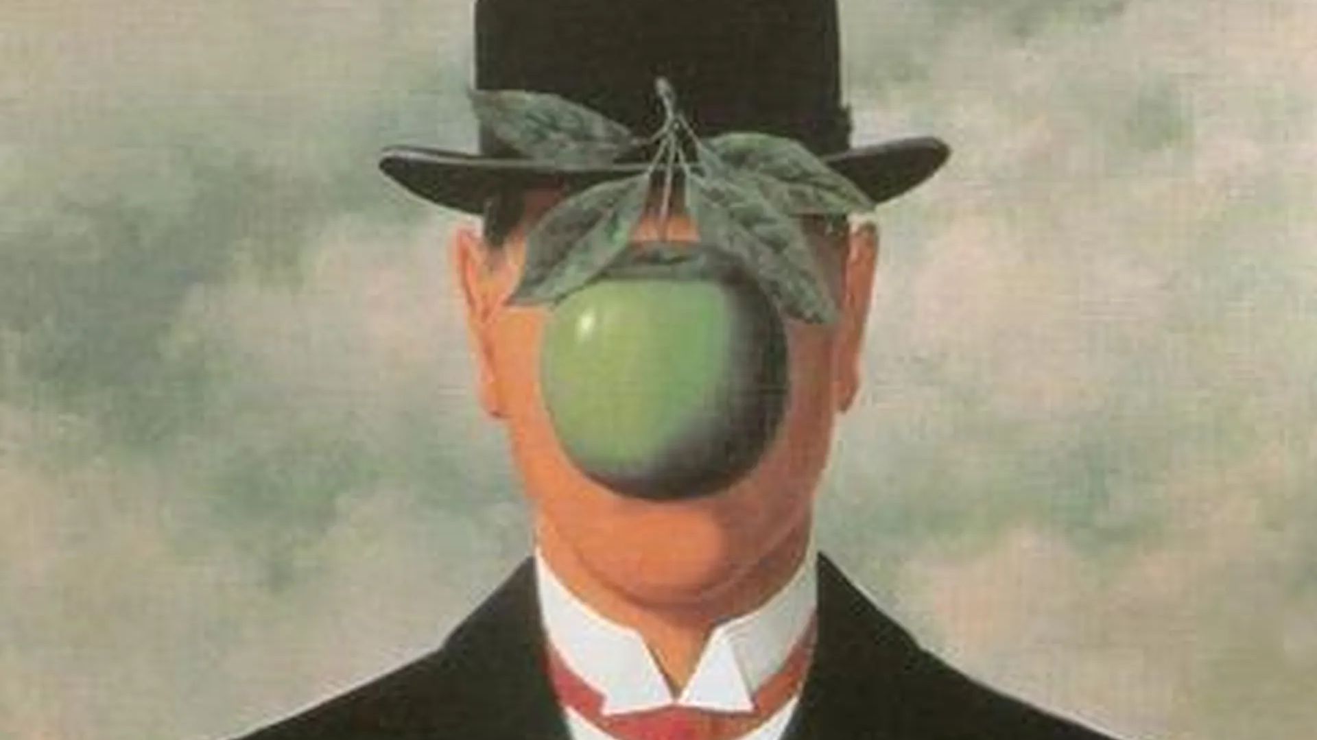 Un uomo in giacca e cravatta e bombetta si staglia contro un cielo nuvoloso con una grande mela verde che gli oscura il volto, le foglie della mela pendono.