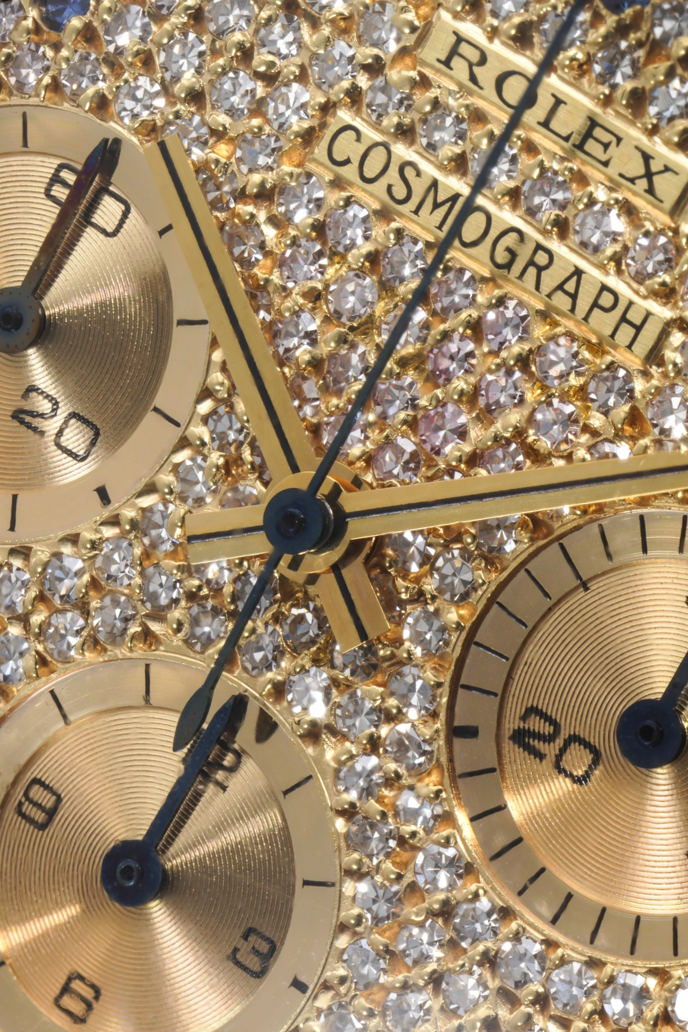 Primo piano del quadrante di un orologio Rolex Cosmograph tempestato di diamanti, con contatori in oro, indici neri e lancette nere: un pezzo iconico recentemente presentato all'asta Phillips 10 anni.