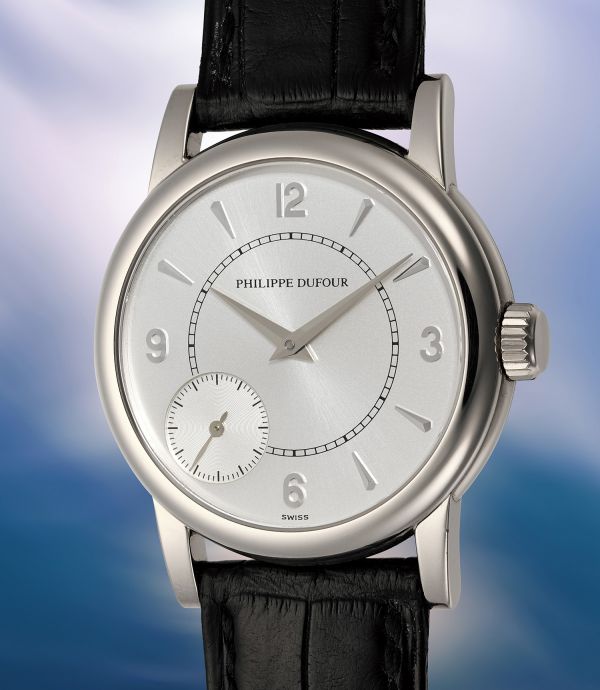Primo piano di un orologio da polso Philippe Dufour con quadrante argentato, indici neri, quadrante dei piccoli secondi a ore 9 e cinturino in pelle nera, su uno sfondo blu e bianco sfocato.