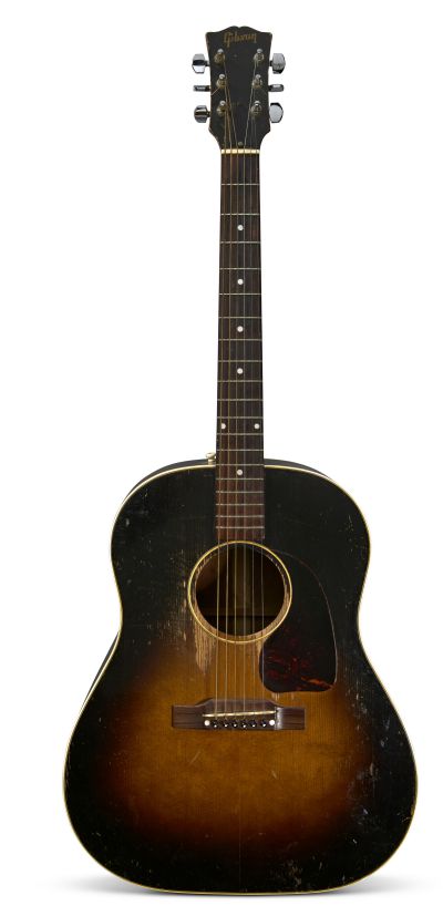 Chitarra acustica Gibson vintage con finitura sunburst, perfetta per qualsiasi collezione rock. Presenta segni di usura, sei corde, intarsi a punti sulla tastiera e battipenna tartarugato.