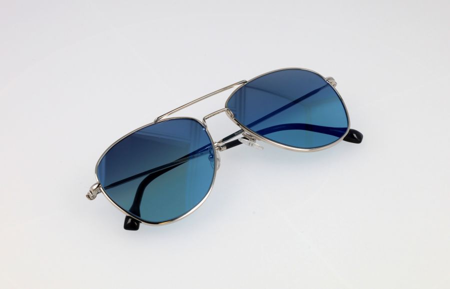 Un paio di occhiali da sole stile aviatore Macron con lenti blu sfumate e montatura argentata, su sfondo bianco.