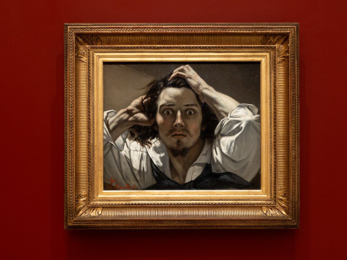 Un dipinto incorniciato di Courbet raffigura un uomo con capelli lunghi e pizzetto che si stringe la testa in preda allo shock. Esposto su una parete rossa con una cornice dorata, questo pezzo di grande effetto aggiunge drammaticità a qualsiasi collezione d'arte del Qatar.