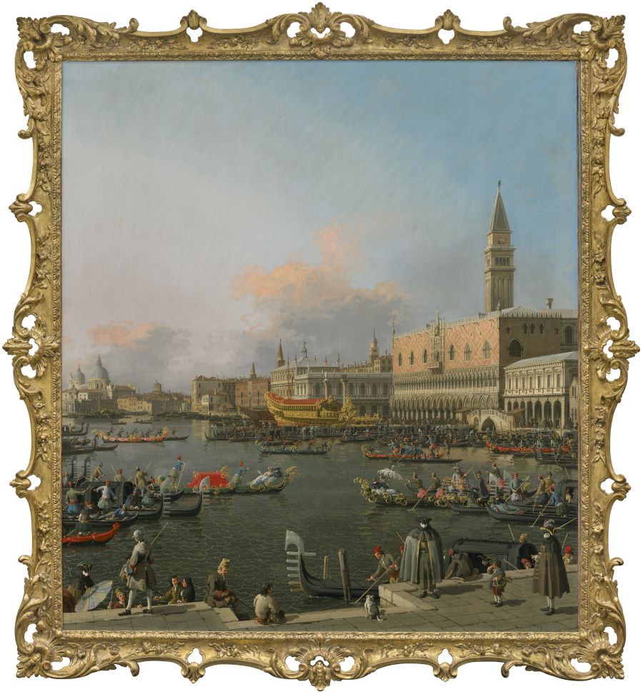 Un dipinto dettagliato in una cornice dorata mostra il Canal Grande di Venezia pieno di gondole e persone, con il Palazzo Ducale e il Campanile di San Marco sullo sfondo sotto un cielo blu con nuvole rosa.