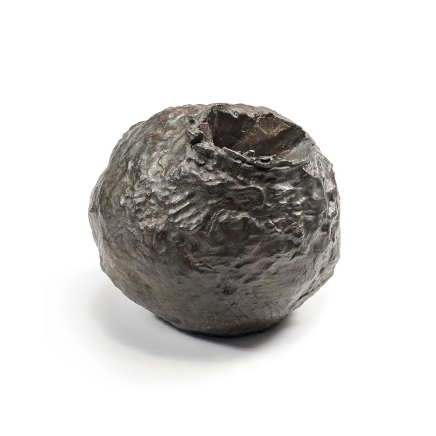 Un vaso rotondo in ceramica o bronzo di colore scuro, dalla texture ruvida e con un'apertura irregolare nella parte superiore, evoca lo spirito di Lucio Fontana Milano, su uno sfondo bianco.